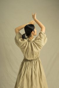 back view of a woman in brown dress 3866555
