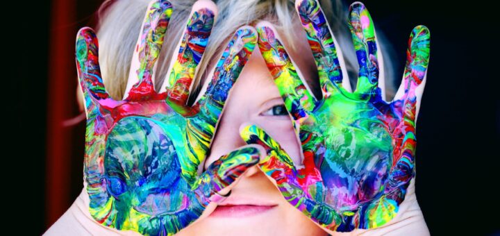 a kid with multicolored hand paint
