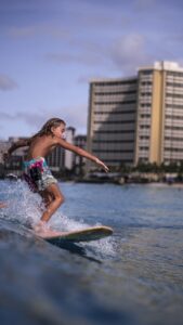 boy practicing in surfing on seawater
